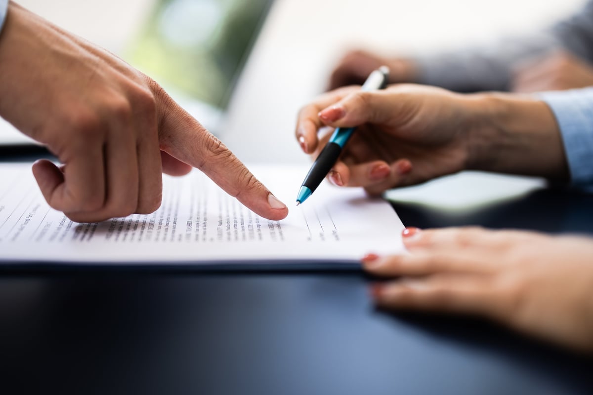 Pointing the finger in front of a person signing the document